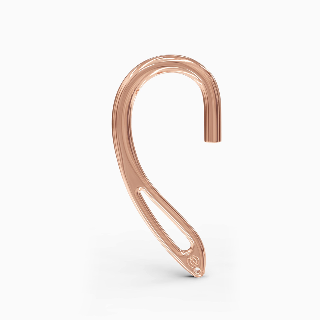 Angled shot of rose gold ear cuff with intricate design and clamp